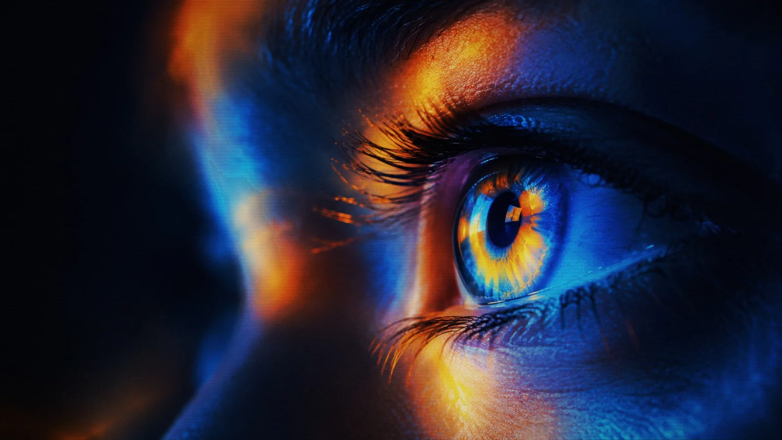 A close-up of an eye illuminated in blue, turquoise and orange.